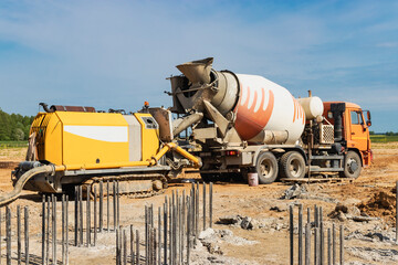 Concrete mixer truck delivers concrete to the pump for pouring piles. Concrete pump at the...
