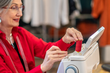 Woman setting up spool of thread on sewing machine