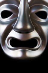 Close up macro image of silver tragedy theatre mask. 