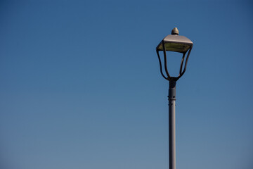 Fototapeta na wymiar Vintage design of an empty metallic street light against blue sky
