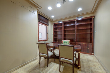 Office with vintage wooden table with matching bookshelf and beige marble floors