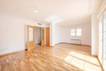 Empty living room with glossy French oak parquet and matching joinery