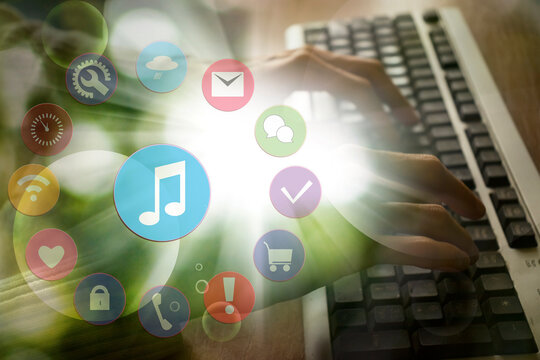 Female hands on laptop keyboard and overlay image of music icon