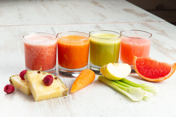 Freshly squeezed juices in glasses on a wooden table.
