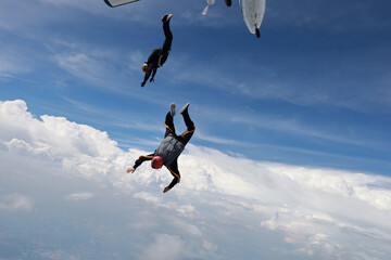 Skydiving. Skydivers are flying in the sky.
