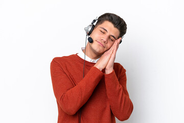 Telemarketer caucasian man working with a headset isolated on white background making sleep gesture in dorable expression