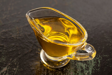 Bowl with olive oil on black wood background.