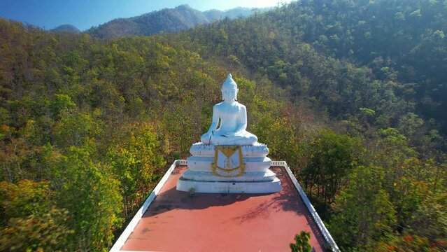 Backward aerial shot of the famous white Buddha statue in Pai, north Thailand