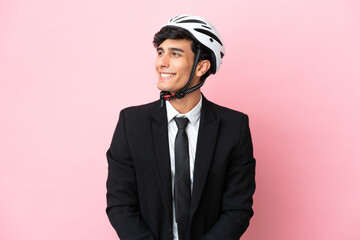 Argentinian businessman with bike helmen isoleted on pink background