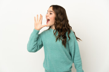 Little caucasian girl isolated on white background shouting with mouth wide open to the side