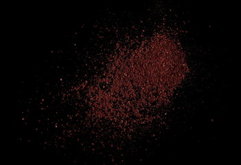 Ground sumac spice, pile isolated on black, top view 