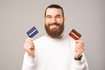 Portrait of a bearded man holding two cards waiting for you to choose.