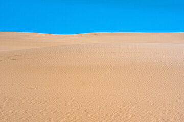 Fototapeta na wymiar lifeless sandy desert landscape under blue sky
