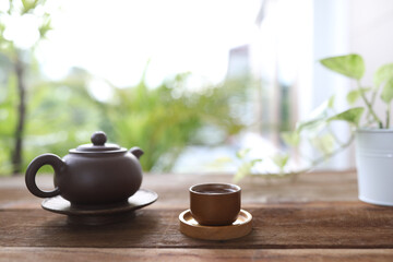 Brown earthenware teapot and tea cup and books