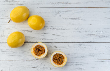 Passion fruits with cut fruit over wooden table with copy space