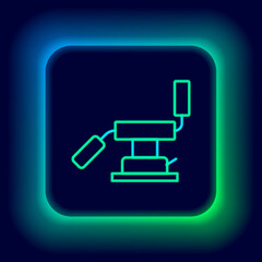 Fototapeta premium Glowing neon line Medical dental chair icon isolated on black background. Dentist chair. Colorful outline concept. Vector