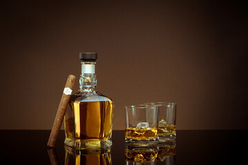 close up view of cigar, bottle of whiskey and two glasses aside on color back.  - 512836666