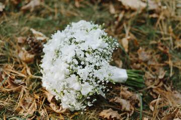 Wedding bouquet of flowers and greenery with white ribbon