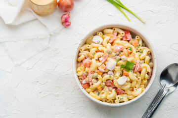 Homemade macaroni salad with elbow pasta, onion, carrot, tomato, green peas and mayonnaise dressing...