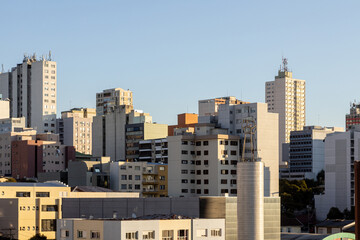 View of buildings in Caxias do Sul city centre at sunset time. Sunlight and blue sky. Rio Grande do Sul state, Brazil