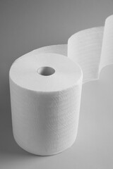 Roll of white paper towels on grey background