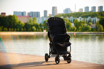 An empty baby stroller left unattended in a city park on the lake.
