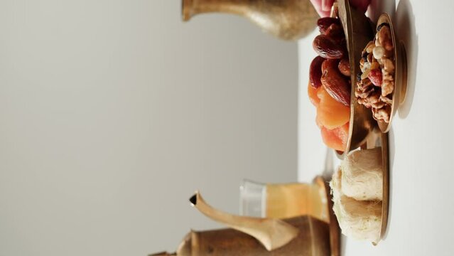 Vertical video of turkish tea and sweets, hot drink in traditional armudu glass close-up. National islamic pastry, treats.