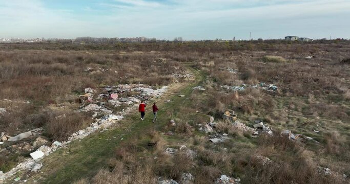 two people walking on a huge aste, garbade, dump, rubbish landill in Bucharest