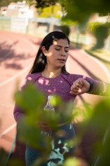 mujer deportista viendo su reloj mientras entrena. Concepto de personas y estilos de vida.