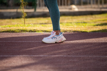 Detalle de pies de mujer en una pista atlética. Concepto de deportes y gente.