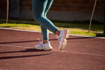 Detalle de pies de mujer corriendo en una pista atlética. Concepto de deportes y gente.