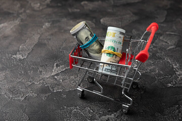 Shopping cart with dollar banknotes on a black background.Business finance shopping concept.Saving...