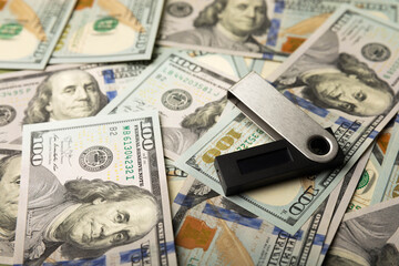 Fototapeta premium Cryptocurrency cold wallet and one hundred dollar banknotes.Business concept.Currency saving. Investment.Cryptocurrency.Bitcoin digital currency.Crypto coin currency storage business concept.