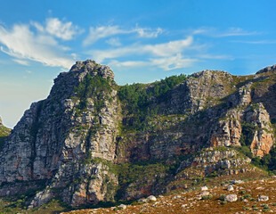 Obraz premium Low angle view of a mountain peak in South Africa. Scenic landscape of a remote hiking location on Lions Head in Cape Town during a sunny day. Travelling and exploring nature through adventure
