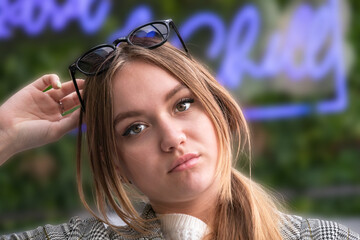 portrait of a beautiful young European girl, 16-17 years old, with long brown hair with a pensive look
