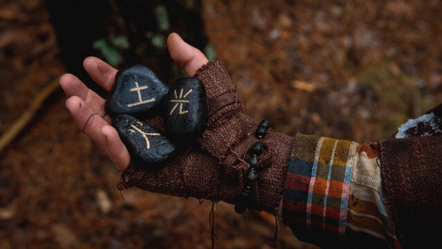 Hand clutching ancient Japanese runes and black