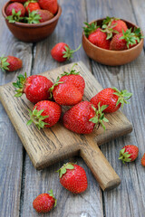 View of juicy fresh strawberries on a wooden table. Vertical. Season, harvest, vitamins