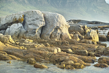 Seascape, landscape, scenic view of boulders and rocks in Hout Bay, Cape Town, South Africa. Ocean, sea washing onto a rocky beach. Travel and tourism abroad, overseas for summer holiday and vacation