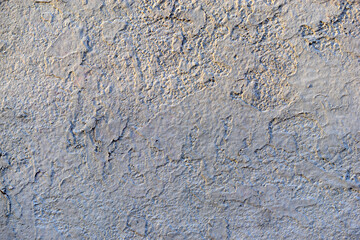 Rough concrete wall with plaster and stones
