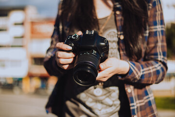 manos de mujer sosteniendo una cámara fotográfica.