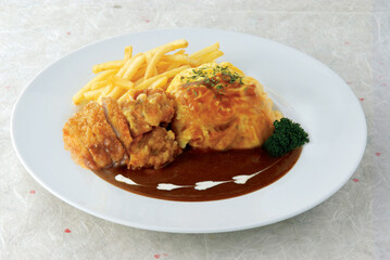 Tonkatsu and Fried Chicken Omu Rice served in a dish isolated on wooden table background side view of singapore food