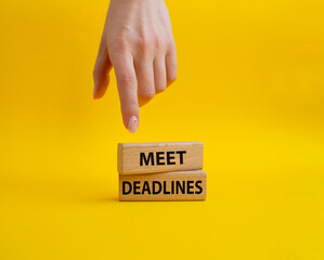 Meet Deadlines symbol. Concept word Meet Deadlines on wooden blocks. Beautiful blue background. Businessman hand. Business and Meet Deadlines concept. Copy space