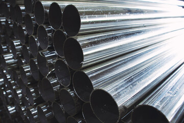 Stainless steel pipe cut with an electric saw, metalworking in a factory close-up