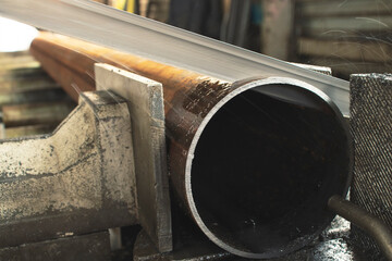 The process of sawing a steel pipe with an electric saw for metal, metalworking close-up at the factory