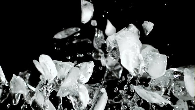 Pieces of ice rise up and fall down. On a black background. Filmed is slow motion 1000 fps.