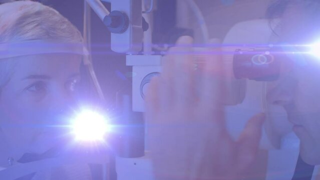 Animation of light trails over diverse doctor and patient using slit lamp