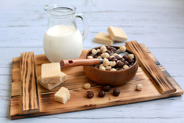 Healthy and nutritious breakfast. Chocolate balls with milk and sweet waffles on a wooden tray