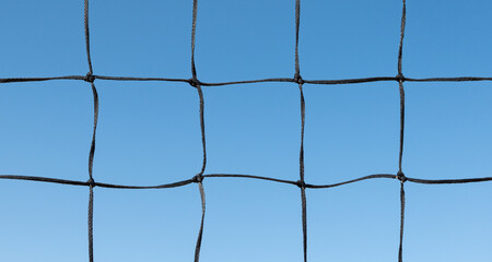 Beach volleyball net pattern against blue sky background. Outdoor sport concept.