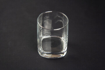 Transparent whiskey glass on black background