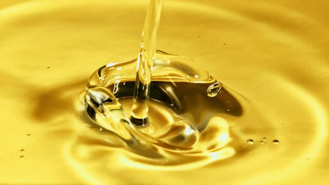 A jet of olive oil pours with air bubbles. Macro background. Filmed is slow motion 1000 fps.